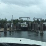 A boat navigating a narrow channel with tall metal structures.