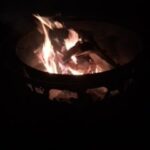 A campfire burning brightly in the darkness.