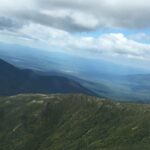 A scenic aerial view of rolling hills and mountains.