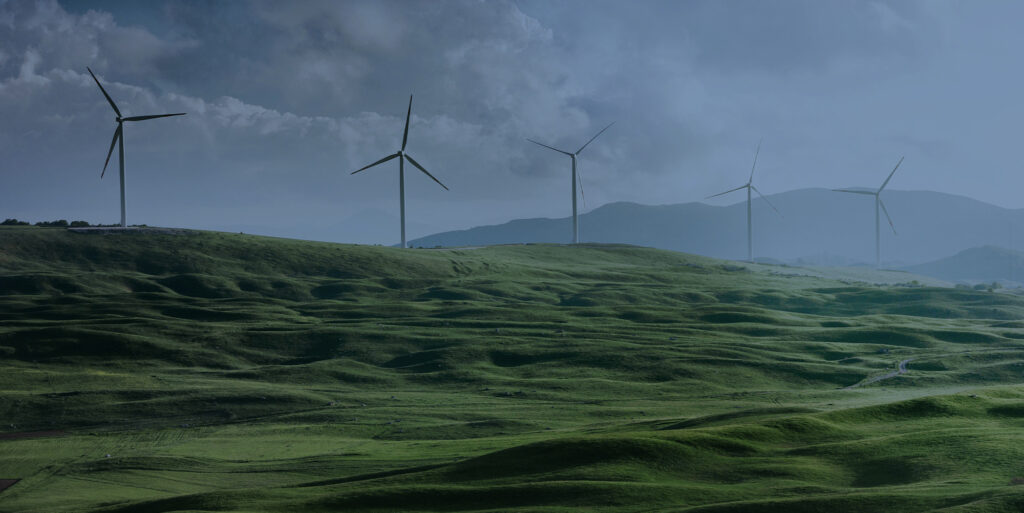 A field of wind turbines stands tall against a dramatic sky, generating clean energy.