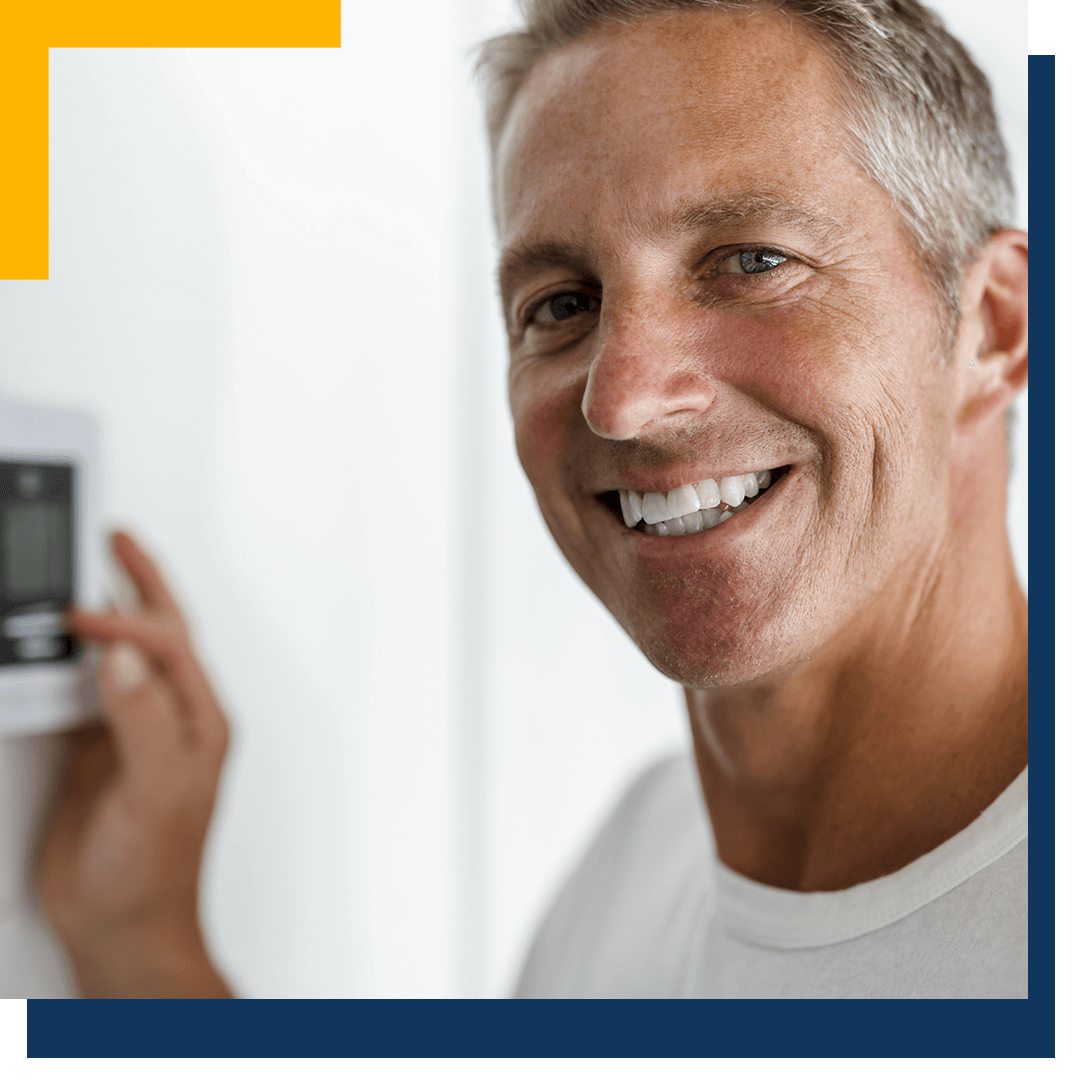 Happy man using thermostat